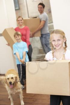 Family with dog on moving day carrying cardboard boxes