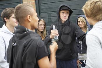 Group Of Threatening Teenagers Hanging Out Together Outside Drinking