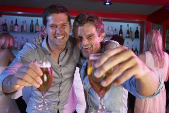 Two Young Men Having Fun In Busy Bar