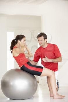 Woman with personal trainer in home gym