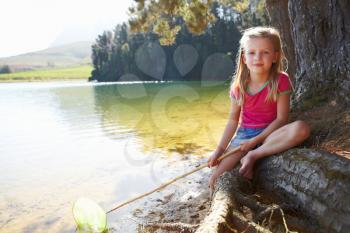 Happy girl fishing at lake