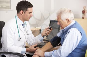 American doctor taking senior man's blood pressure