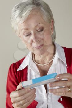 Senior woman looking at prescription drug pack