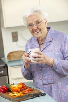 Senior woman preparing food in domestic kitchen