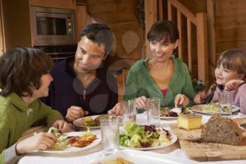 Family Enjoying Meal In Alpine Chalet Together