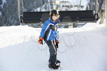 Young Boy Getting Off chair Lift On Ski Holiday In Mountains