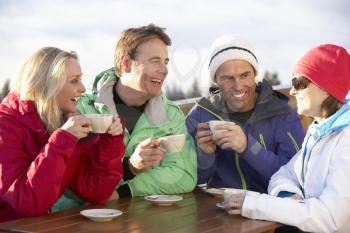 Group Of Friends Enjoying Hot Drink In Caf At Ski Resort