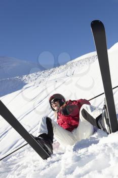 Female Skier Sitting In Snow With After Fall