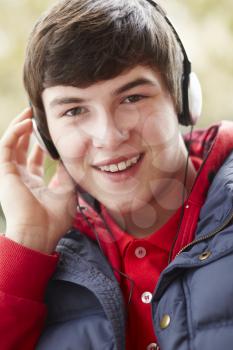 Teenage Boy Wearing Headphones And Listening To Music Wearing Winter Clothes