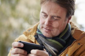 Man Texting On Smartphone Wearing Winter Clothes
