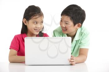 Studio Shot Of Two Chinese Children With Laptop