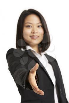 Studio Portrait Of Chinese Businesswoman Reaching Out To Shake Hands