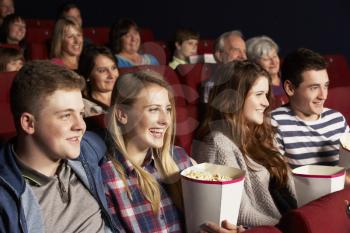 Group Of Teenage Friends Watching Film In Cinema