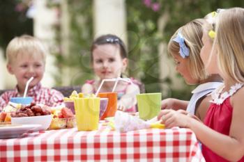 Group Of Children Enjoying Outdoor Tea Party