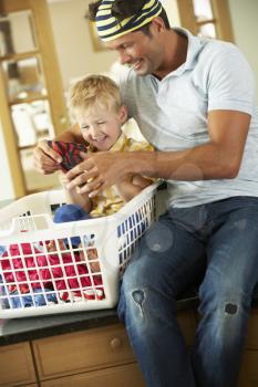 Father And Son Sorting Laundry Sitting On Kitchen Counter