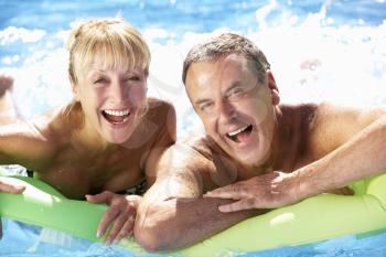 Senior Couple Having Fun In Swimming Pool