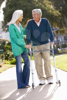 Senior Woman Helping Husband With Walking Frame