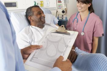 Doctor Looking At Chart With Senior Male Patient