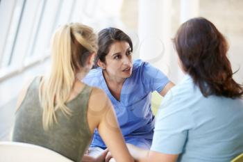 Nurse Meeting With Teenage Girl And Mother In Hospital