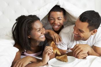 Family Enjoying Breakfast In Bed