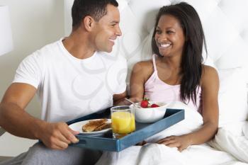 Man Bringing Woman Breakfast In Bed On Tray