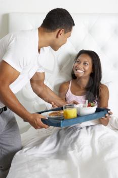 Man Bringing Woman Breakfast In Bed On Tray