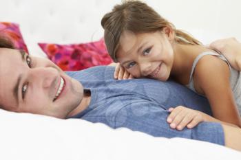 Father And Daughter Lying In Bed Together