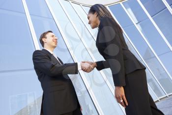 Businessman And Businesswomen Shaking Hands Outside Office