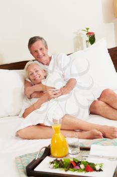 Senior Couple Relaxing In Hotel Room Wearing Robes