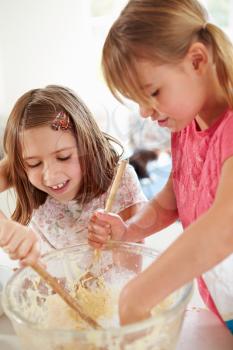 Two Girls Making Cupcakes In Kitchen