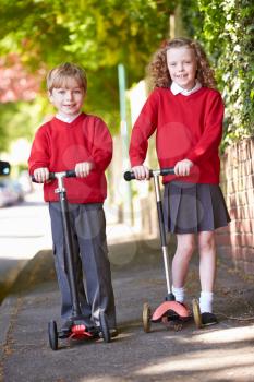 Boy And Girl Riding Scooter On Their Way To School