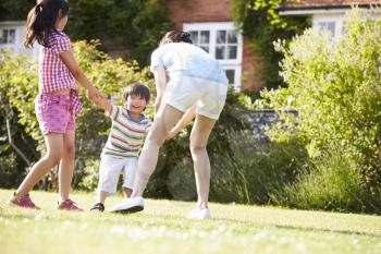 Asian Mother Playing In Summer Garden With Children