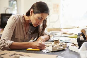 Female Architect Making Model In Office