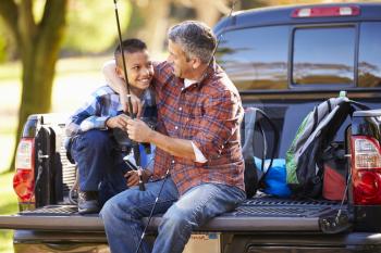 Father And Son Sitting In Pick Up Truck On Camping Holiday