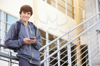 High School Student Standing Outside Building With Phone