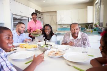 Multi-Generation Family Sitting Around Table Eating Meal