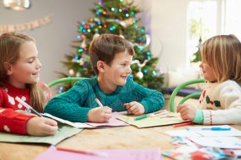 Three Children Writing Letters To Santa Together