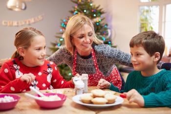 Mother And Children Decorating Christmas Cookies Together