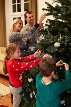 Family Decorating Christmas Tree At Home Together