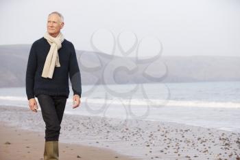 Senior Man Walking Along Winter Beach