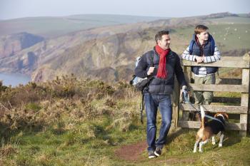 Father And Son With Dog Walking Along Coastal Path