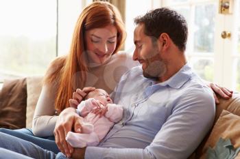 Mother And Father At Home With Newborn Baby