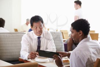 Businessmen Meeting Over Breakfast In Hotel Restaurant