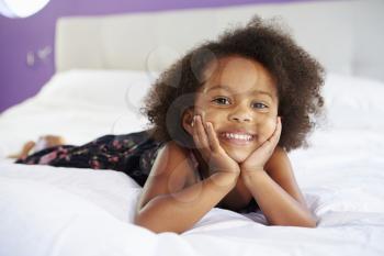 Cute Little Girl Lying On Tummy In Parent's Bed