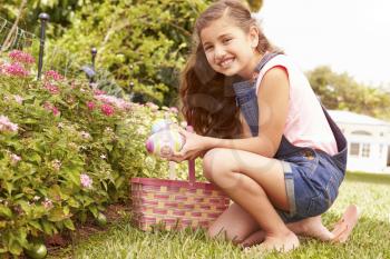 Girl Having Easter Egg Hunt In Garden