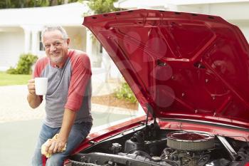 Retired Senior Man Working On Restored Classic Car