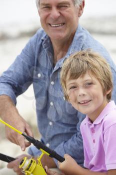 Young boy fishing with grandfather