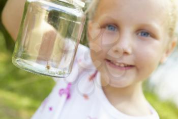 Little girl with cricket in a jar