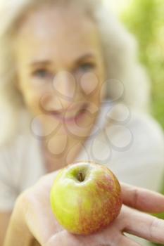 Senior woman eating apple outdoors