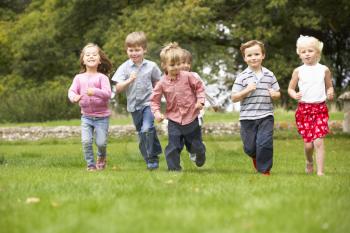 Small group young children running in park